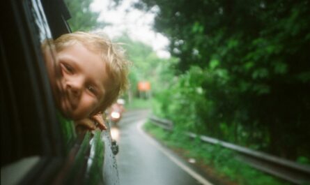 child peeking from vehicle window